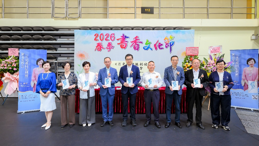 图为作者（左）向主礼嘉宾赠书。
